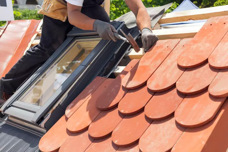 Dachdecker baut ein Dachfesnter in ein neugedecktes Dach ein